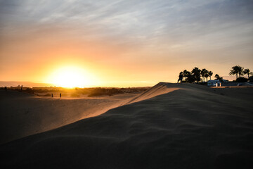 Fototapeta na wymiar Violet and orange sunset in the sand dunes of Maspalomas, Gran Canaria.