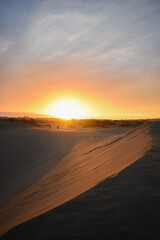 Fototapeta na wymiar Violet and orange sunset in the sand dunes of Maspalomas, Gran Canaria.
