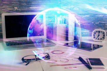 Obraz premium Computer on desktop in office with technology theme hologram. Double exposure. Tech concept.