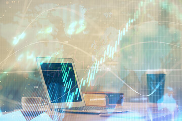 Stock market graph on background with desk and personal computer. Multi exposure. Concept of financial analysis.