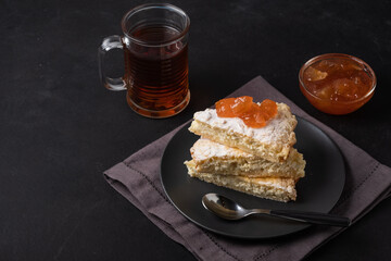 Appetizing cottage cheese pie with apple jam and tea on black background . Tasty and healthy, delicious, homemade.