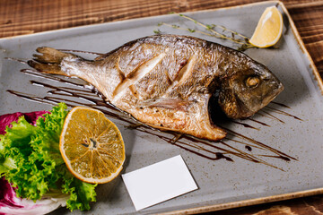 Smoked dorado fish with herbs on wooden background