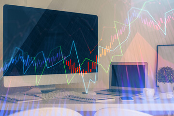 Stock market graph on background with desk and personal computer. Multi exposure. Concept of financial analysis.