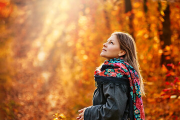Fototapeta na wymiar Portrait of beautiful smiling woman posing in autumn forest with cup of tea