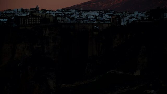 Tourist attraction in Spain. The Puente Nuevo New Bridge in Ronda, Andalusia. Travel destination, landmark. Time lapse of night is falling over town.