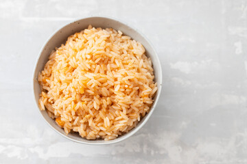 boiled rice with tomato in bowl on ceramic background