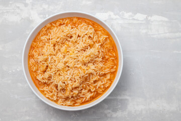 boiled rice with tomato in bowl on ceramic background