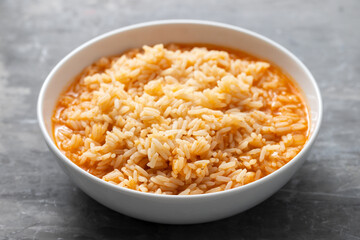 boiled rice with tomato in bowl on ceramic background
