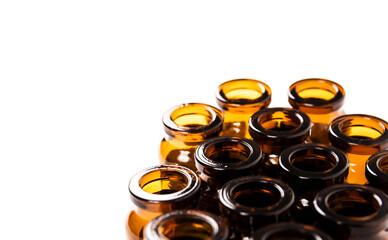 Many empty brown glass medical bottles isolated on a white background. The course of treatment is completed. Mass vaccination. Capacities for tablets. Production of containers.