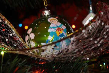 Christmas balloon with the image of the snow maiden, hanging on the branch of the Christmas tree. Christmas background with Christmas decorations.