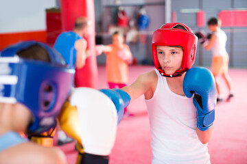 Young boys and girl practicing boxing punches with his coach