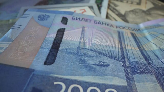 Two thousand russian rubble in macro shot. Crimea bridge with ship and seagull as symbol of this bill. Texture. Many american dollars on the background. Concept - Finance Business Investment Success.