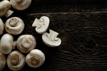 Fresh champignon mushrooms on wooden table, closeup. Space for text