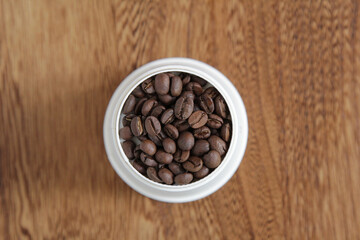 coffee beans in a white cup on the dark table