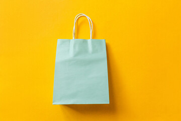 Simply minimal design shopping bag isolated on orange background. Online or mall shopping shopaholic concept. Black friday Christmas season sale. Flat lay top view copy space, mock up