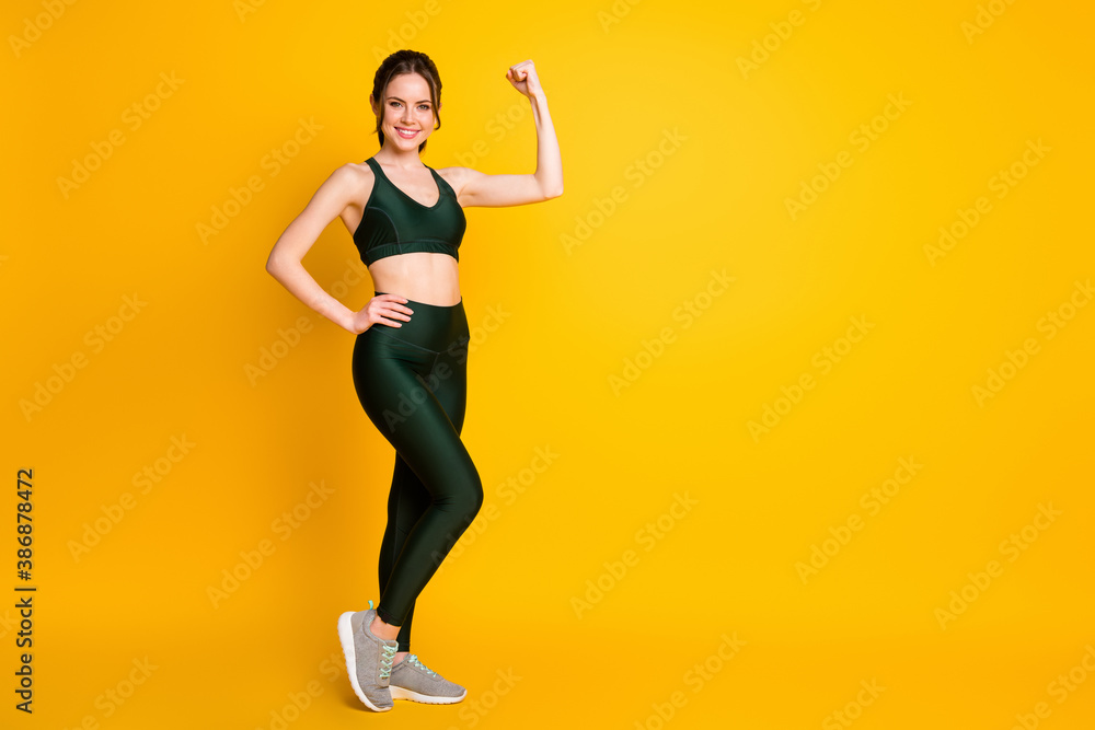 Poster Full length body size view of her she nice attractive cheerful sportive girl posing demonstrating biceps isolated bright yellow color background