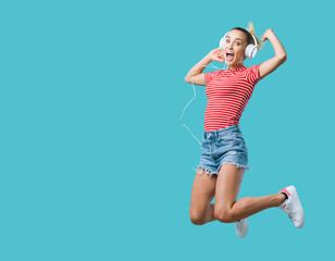 Cheerful woman listening to music and jumping