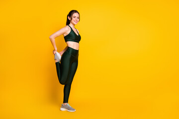 Fototapeta na wymiar Full length body size profile side view of her she nice cheerful girl doing physical exercise stretch isolated on vibrant yellow color background