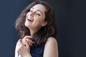 Obraz premium Happy girl smiling. Beauty portrait young happy positive laughing brunette woman on black background isolated. European woman. Positive human emotion facial expression body language