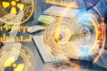 Technology theme hologram with man working on computer on background. High tech concept. Multi exposure.