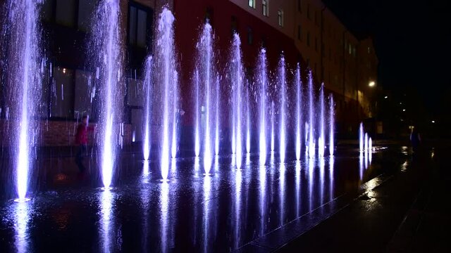 Beautiful musical fountain with colorful illumination in the evening in Kiev Ukraine 4k video
