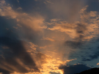 Dramatic sky with clouds at sunset. Skyscape with ray beams.