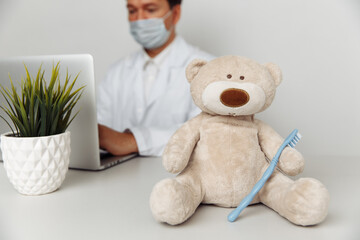 Teddy Bear with toothbrush at dentist's office. Child healtcare and treatment concept.