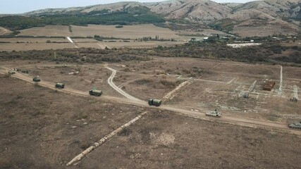 Military convoy moves frame with aerial