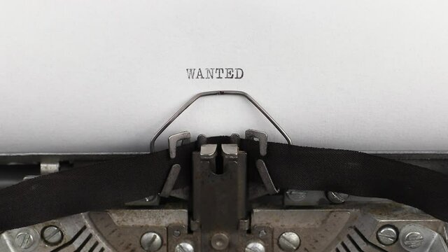 to type word wanted on a vintage and old typewriter close-up