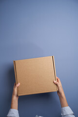 Woman hands open empty cardboard box, top view