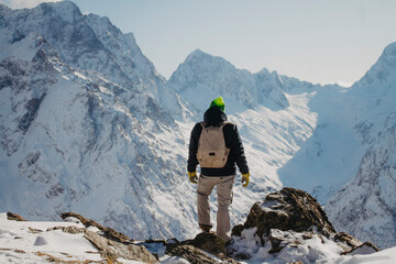 Winter traveler in the mountains. Rocky mountains of Dombai, Caucasus.