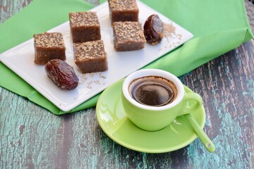 Dates tahini square sweet bites topped with sesame seeds. Served with espresso coffee.
