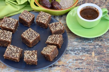 Dates tahini square sweet bites topped with sesame seeds. Served with espresso coffee.
