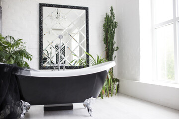 Stylish washroom with big black and white bathtub