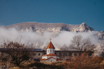 Church in the mountains. Beautiful landscape of mountains in the clouds.