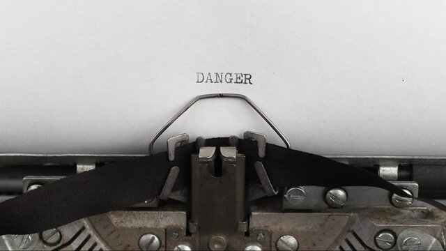 to type a quote danger on a vintage and old typewriter close-up
