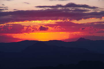オレンジ色に染まる空と山の稜線のシルエット