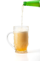 Beer is poured into a glass on a white background. Clipping path included