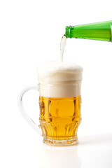 Beer is poured into a glass on a white background.