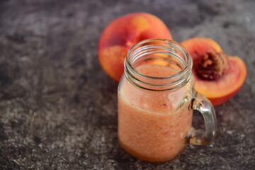 Healthy fresh nectarine smoothie in a jar on grey background