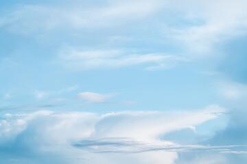 Light blue sky with fluffy clouds for relaxing background or wallpaper