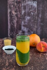 Healthy mango peach smoothie with spirulina and maca powder