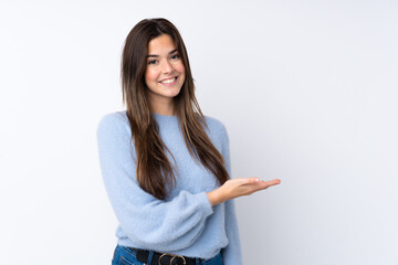 Teenager girl over isolated white background presenting an idea while looking smiling towards