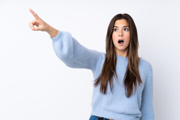 Teenager girl over isolated white background pointing away