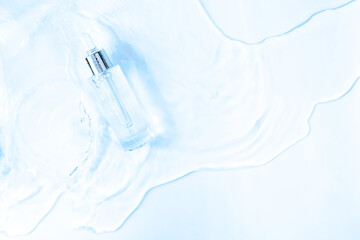 Glass Bottle with fluid collagen and hyaluronic acid, hydration skin. Top flatlay view copyspace. Abstract water blue background
