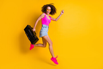 Full body photo of funny curly hipster dj lady hold retro tape boom box hurry event holiday jump...