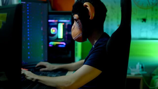 Gamer playing computer action game wearing monkey mask.