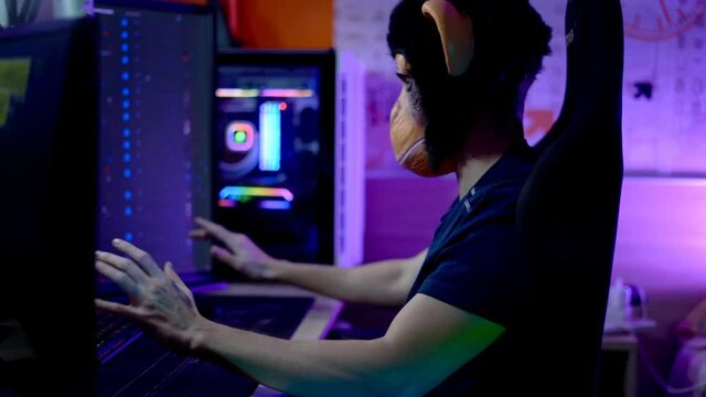 Gamer playing computer action game wearing monkey mask. Ungry.