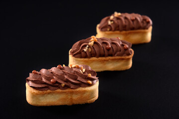 Three cookies with brown whipped cream on top.