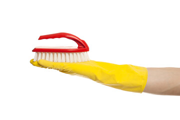 Hand in yellow glove with a red cleaning brush on a white background. Home cleaning concept